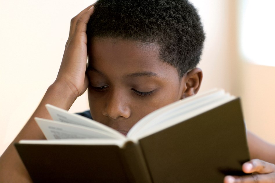 Reading school life. Африканец читает книгу.